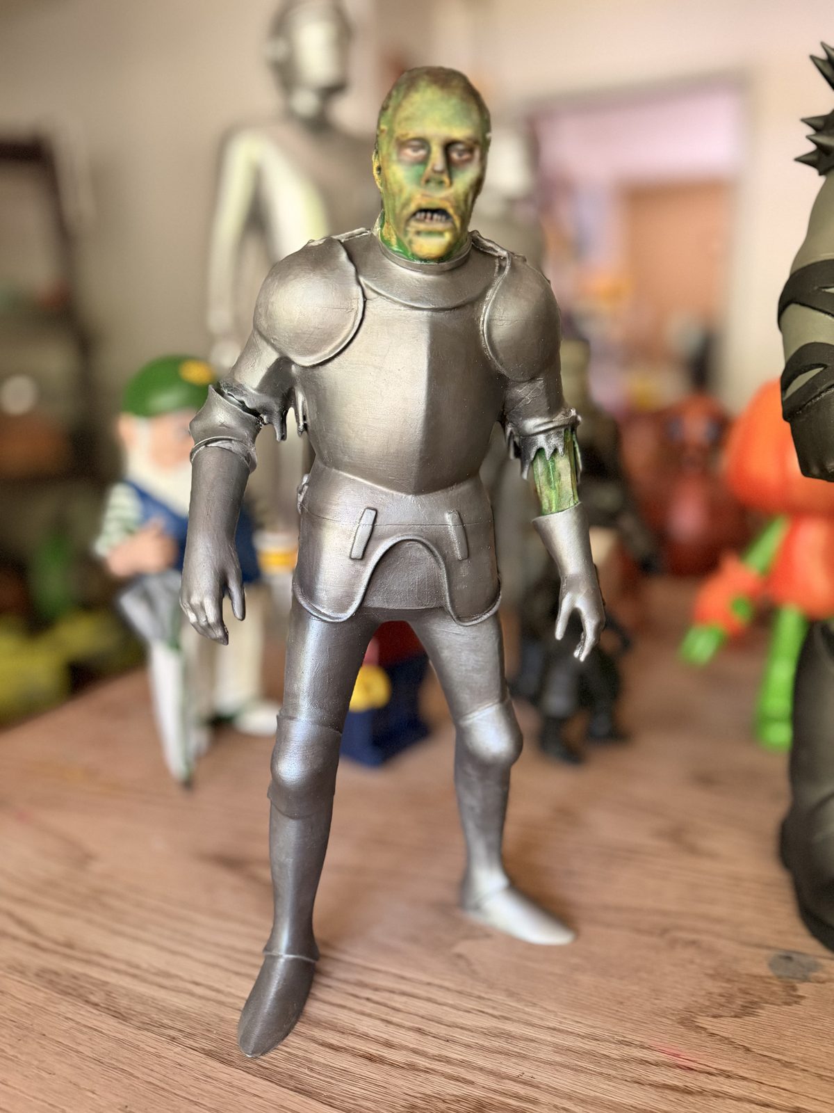 Silver-armored figure with a green stone-textured face mask.